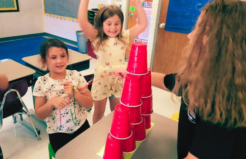2nd grade students team building with cups