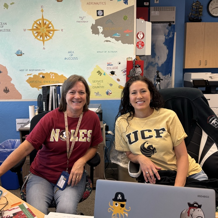 two faculty members sitting at front desk