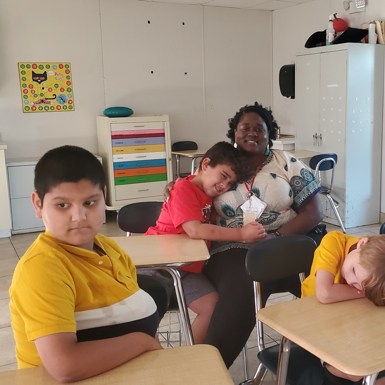 students with caring teacher assistant