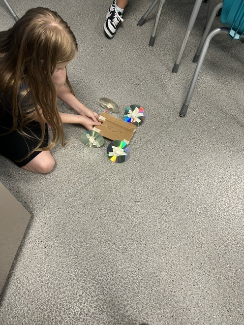 Girt testing her STEM project on the floor.