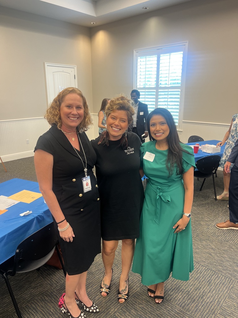 Dr. Christina Jacobs, Chief of Staff for the School District of Indian River County, stands on the left alongside Anna Tillery from White Glove Moving & Storage in the center and Dr. Kyra Schafte, Director of Strategic Communications and Marketing, on the right. The three smile together at the Realtors Association of Indian River County event on October 15, 2026.