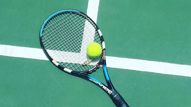 tennis racket and tennis ball  laying on a tennis court