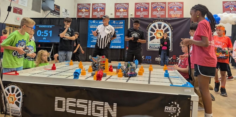 students competing on a VEX Robotics field.