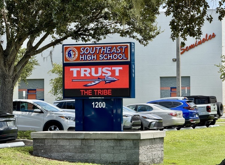 The school marquee with the words, trust the tribe on them