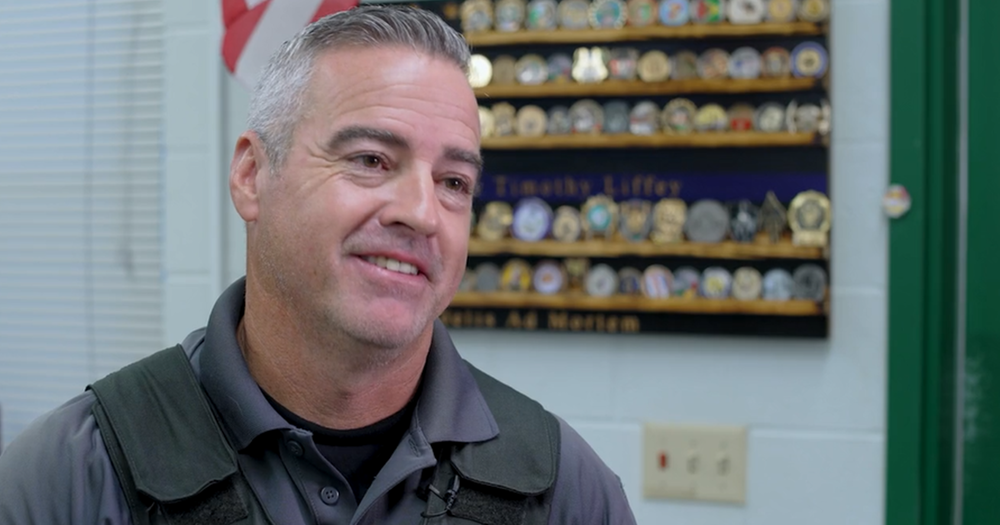 A school safety officer smiles in his office.
