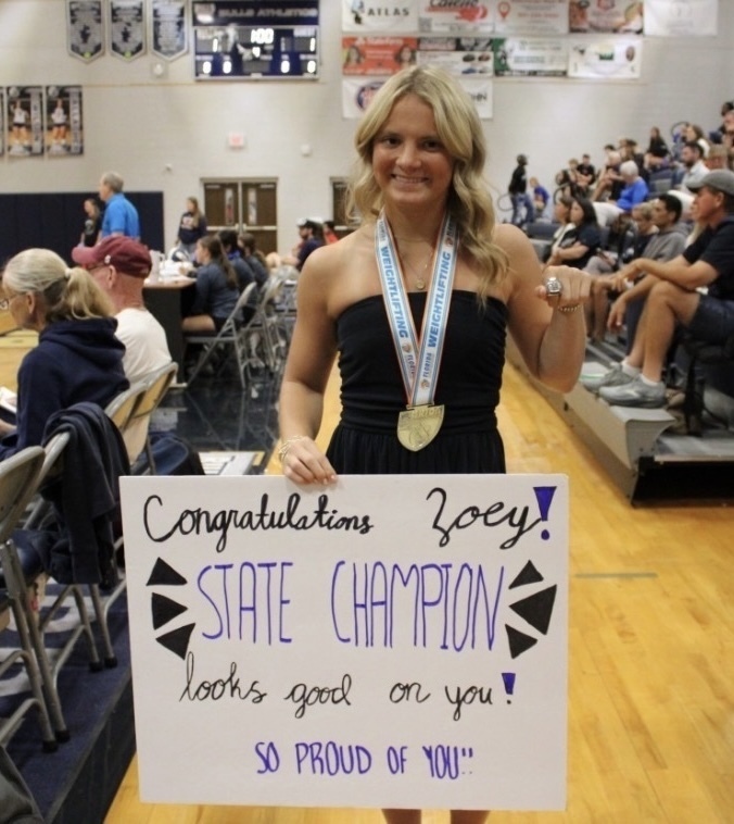 Zoey Morelli with her state champion ring and a poster.
