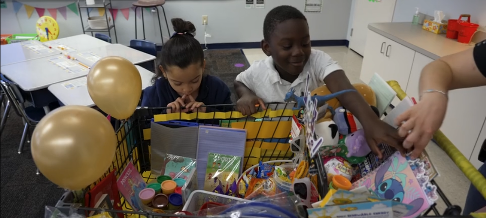Children look into a cart filled with goodies.