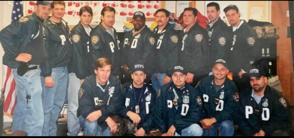 NYPD officers standing in front of a homemade American flag after September 11, 2001