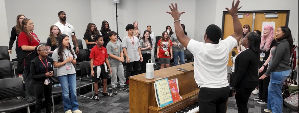 Students and staff singing in a music classroom
