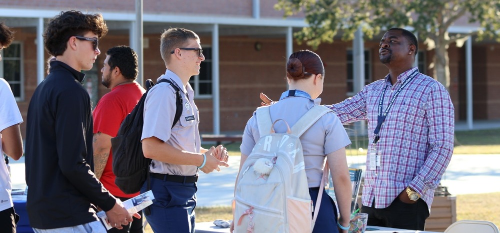 a vendor speaking to teens in a school courtyard.