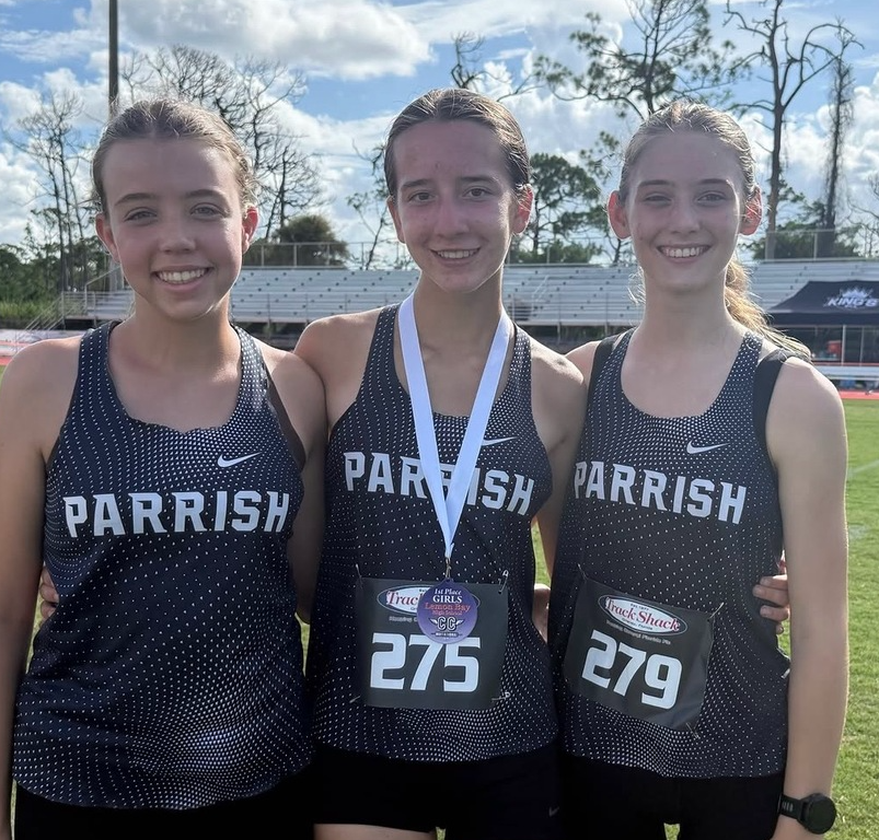Kayla Hawk with fellow cross country runners after her first place finish