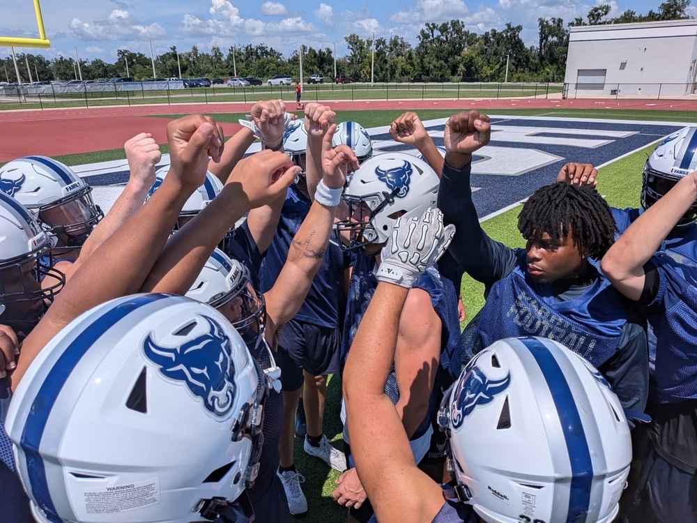 Bulls football players in a team huddle