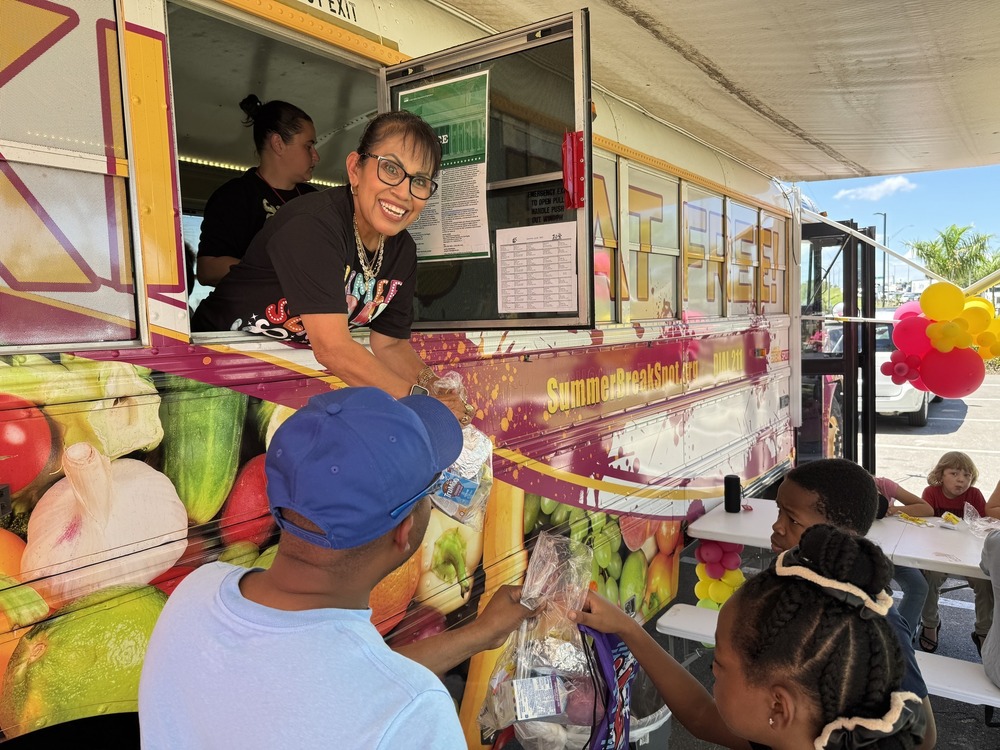 happy food service worker hands meals to children