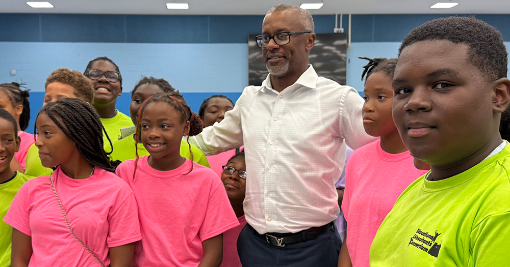 Ravens assistant head coach Willie Taggart stands among smiling kids from Palmetto