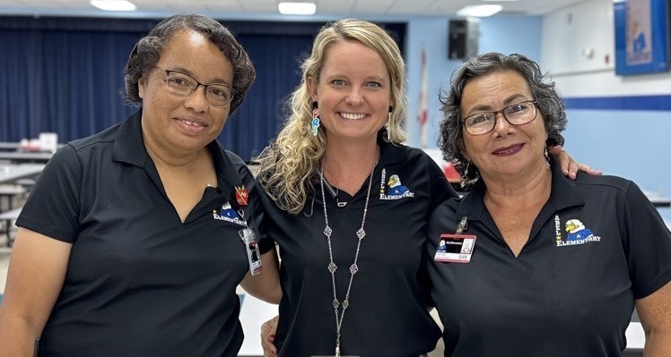 -3 women smiling in a school cafeteria