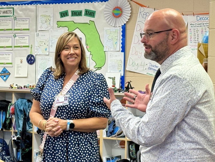 A teacher smiles as the Florida teacher of the year, speaks to her classroom