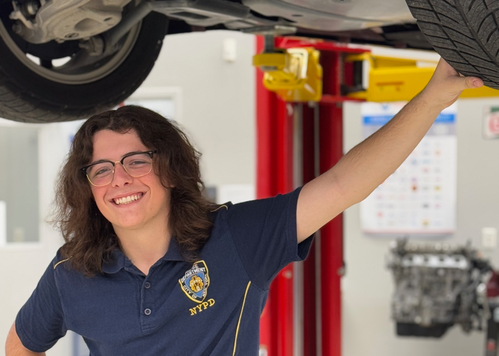 A student holding on to a tire in the automotive shop at Parrish Community High