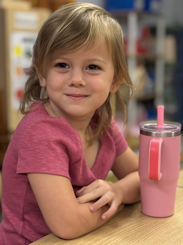 A young girl smiles while wearing red