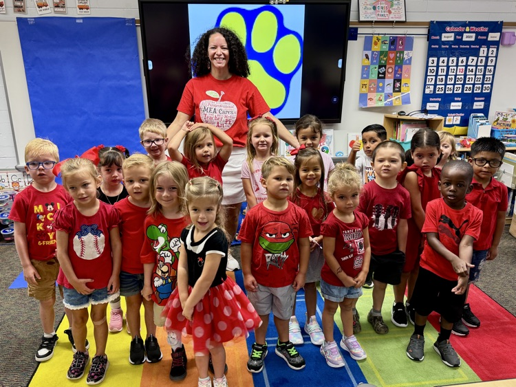 A class of young students and their teacher showing off their outfit