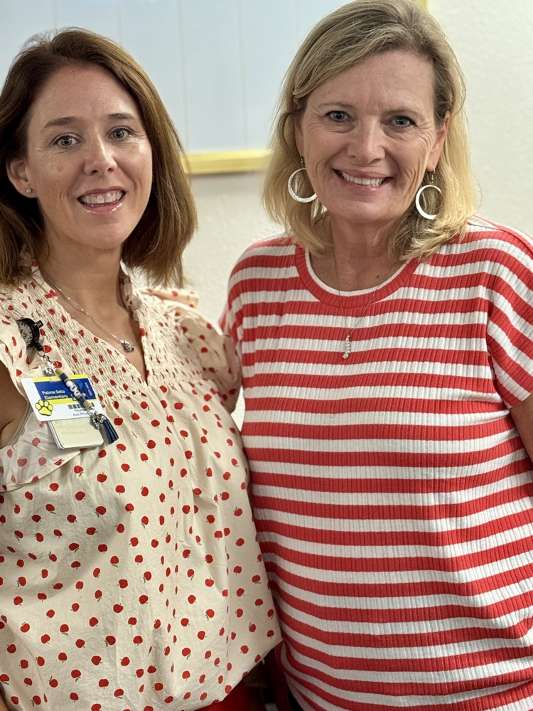 The principal and assistant principal of a school, smiling shoulder to shoulder