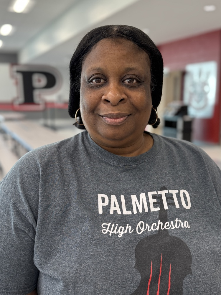 A smiling lunch Lady wearing a high school T-shirt