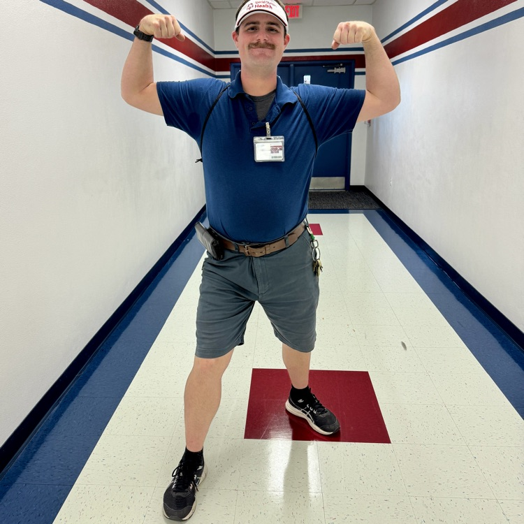 A custodian holding up his arms as if he’s a superhero