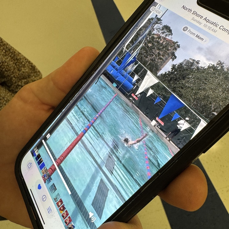 A screenshot of a swim meet video playing on a phone