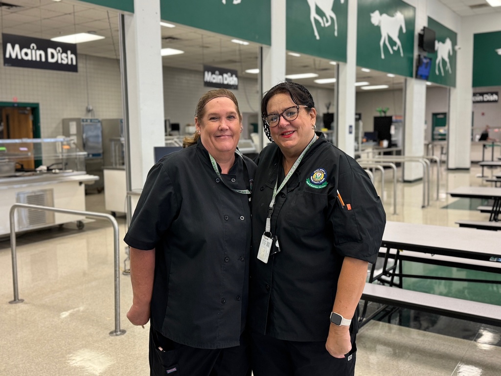 Two school lunch ladies smile inside the cafeteria at Lakewood Ranch High School