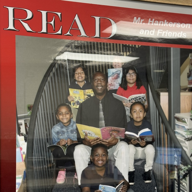 A framed image of a late educator surrounded by students