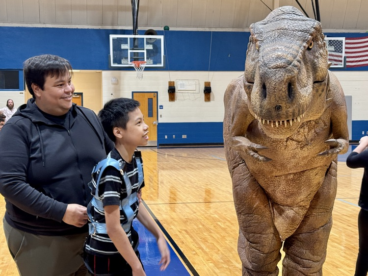 An animatronic dinosaur greet students in the school