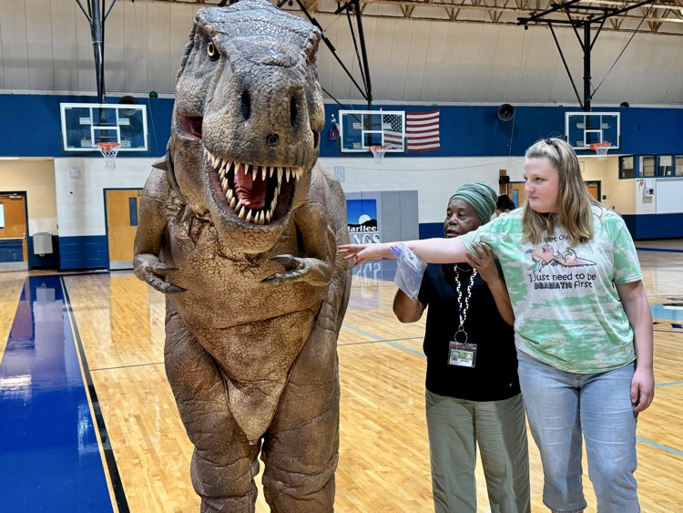Kids carefully reach to pet and the animatronic dinosaur