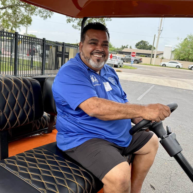 A man behind the wheel of a golf cart.