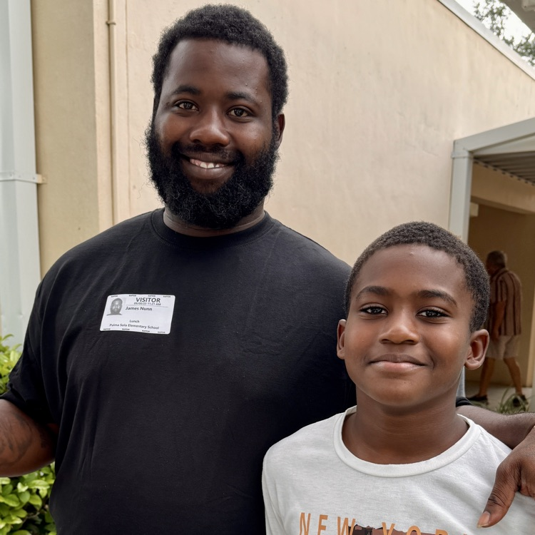 A man and boy smiling at a school. 