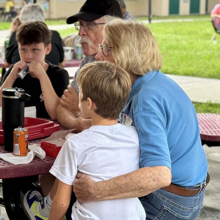 A woman has her arm around her grandchild. 