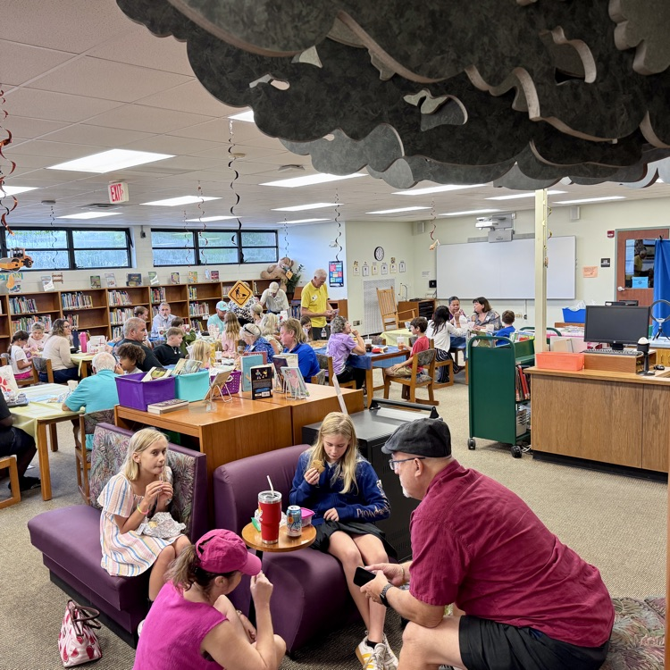 Families enjoying a special lunch in the cafeteria .
