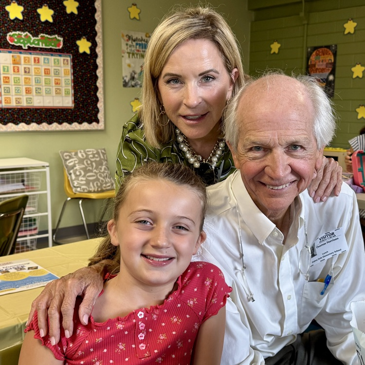 grandparents smiling while having lunch with grandchild.