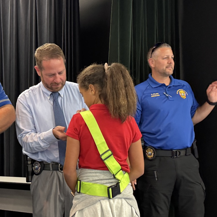 A school safety patrol earns her pin from a Bradenton police officer