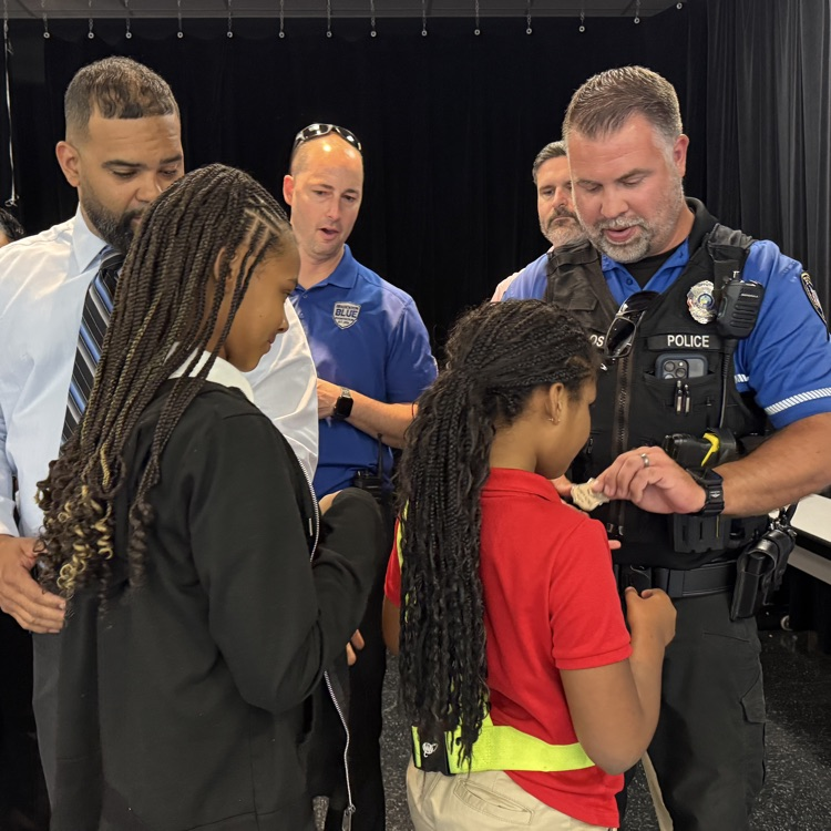 Students receiving their safety patrol pins from police officers