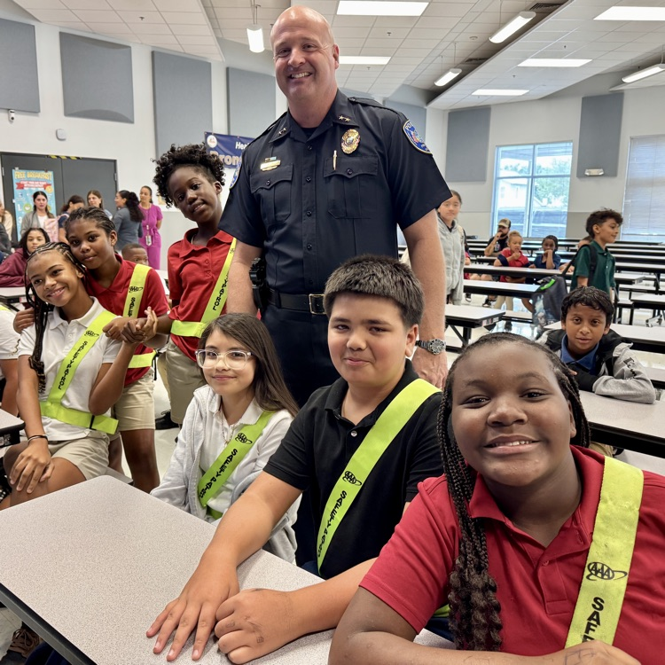 students smile as they are joined by the assistant, chief of police