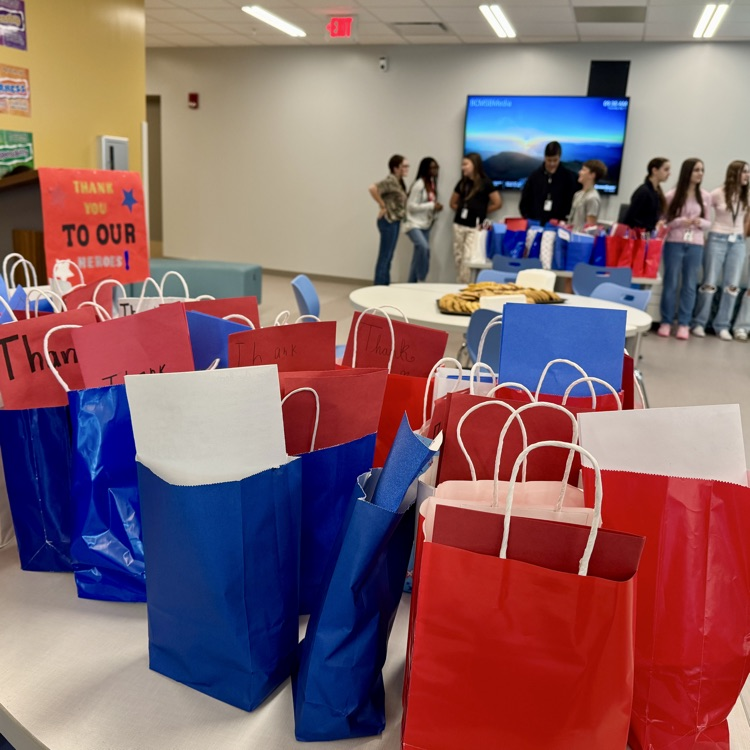A bunch of red and blue gift bags packed with goodies for first responders