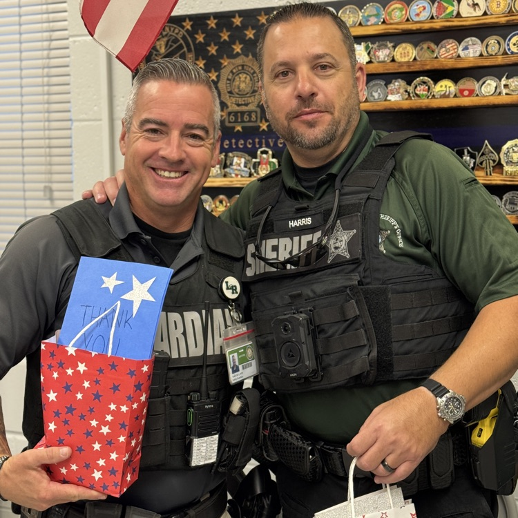 two school safety officers hold gift bags provided by students from Buffalo Creek middle school