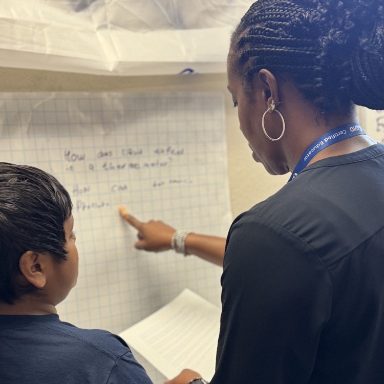 An educator helps students complete a project. 
