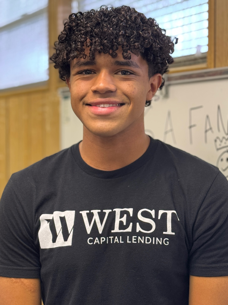 A smiling student wearing a black t-shirt that reads, West Capital Lending