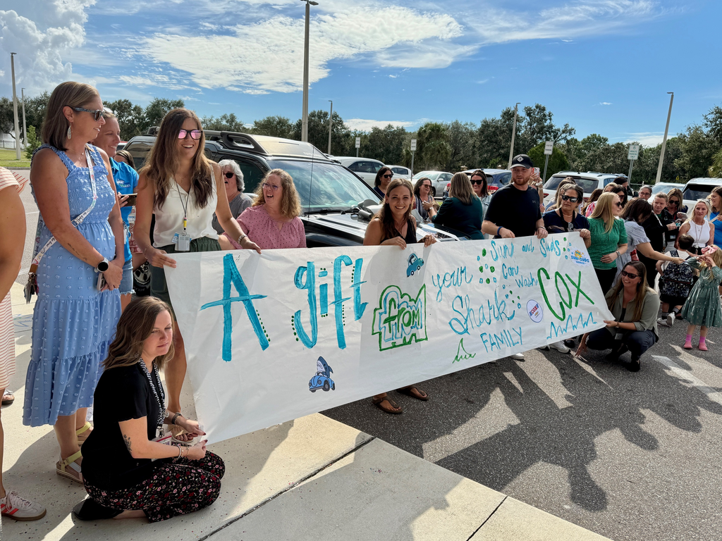 The Harvey K-8 family awaits their colleague to surprise her with a vehicle.