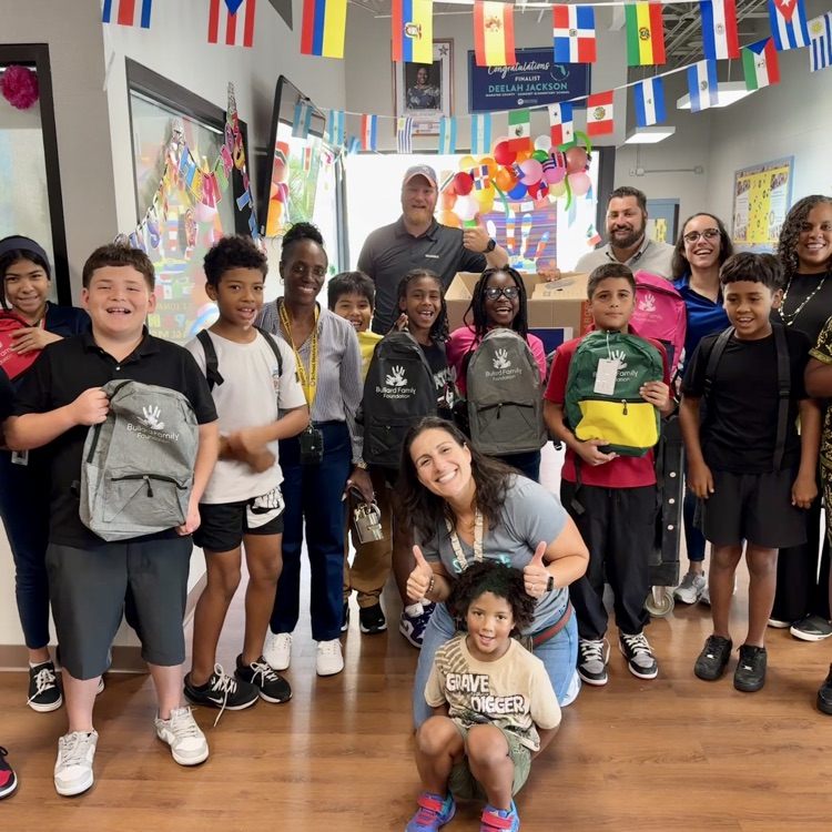 adults and children smiling during a school supply delivery to Samoset elementary