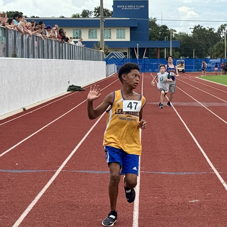 A middle school student runs his heart out on a red track