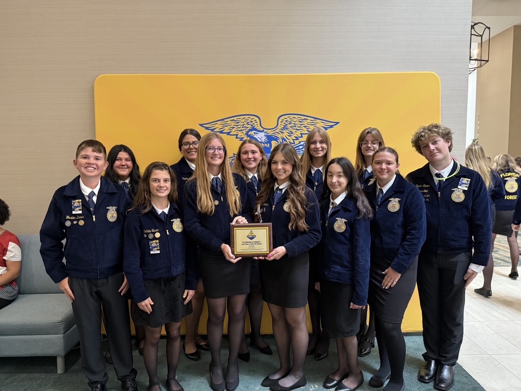 FFA students holding an award plaque from the national organization.