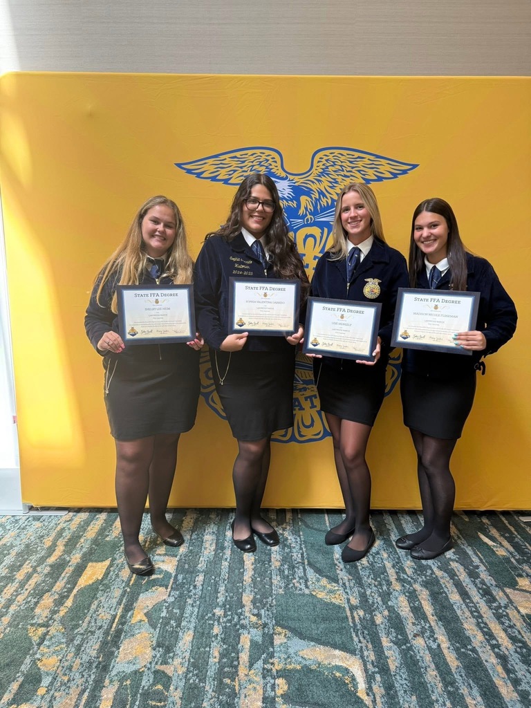 Four FFA members holding a certificate in front of the logo for the national student organization