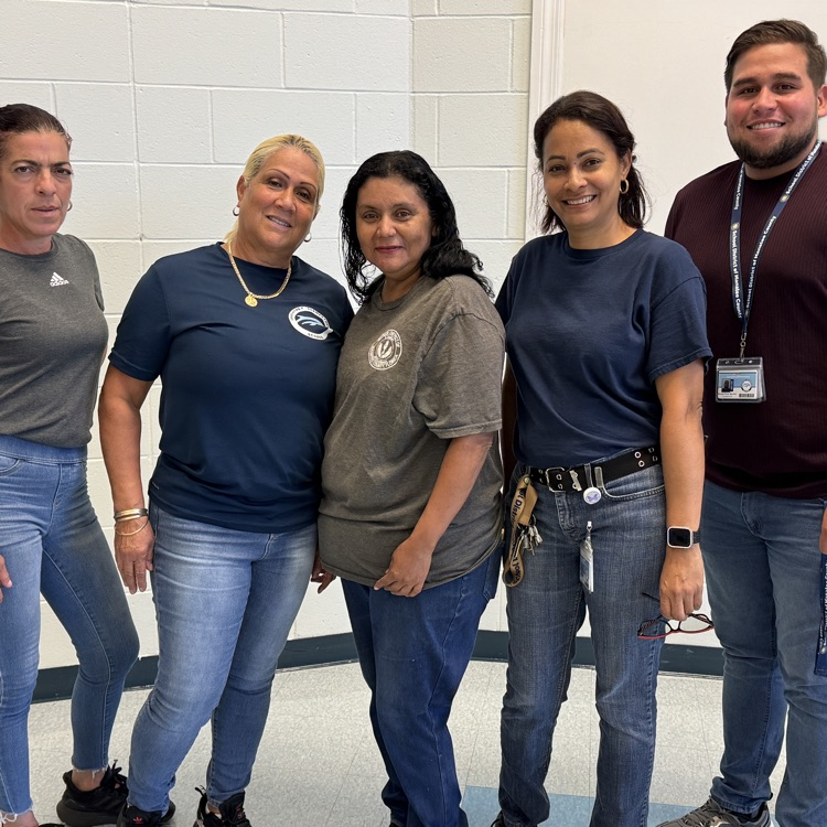 School custodians standing shoulder to shoulder as a team