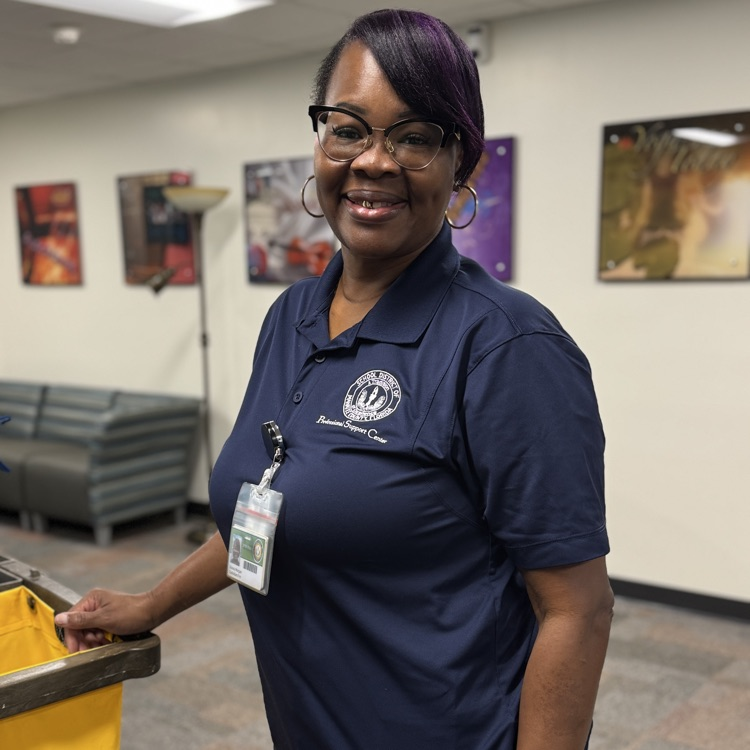 A custodian wearing a blue shirt and glasses.